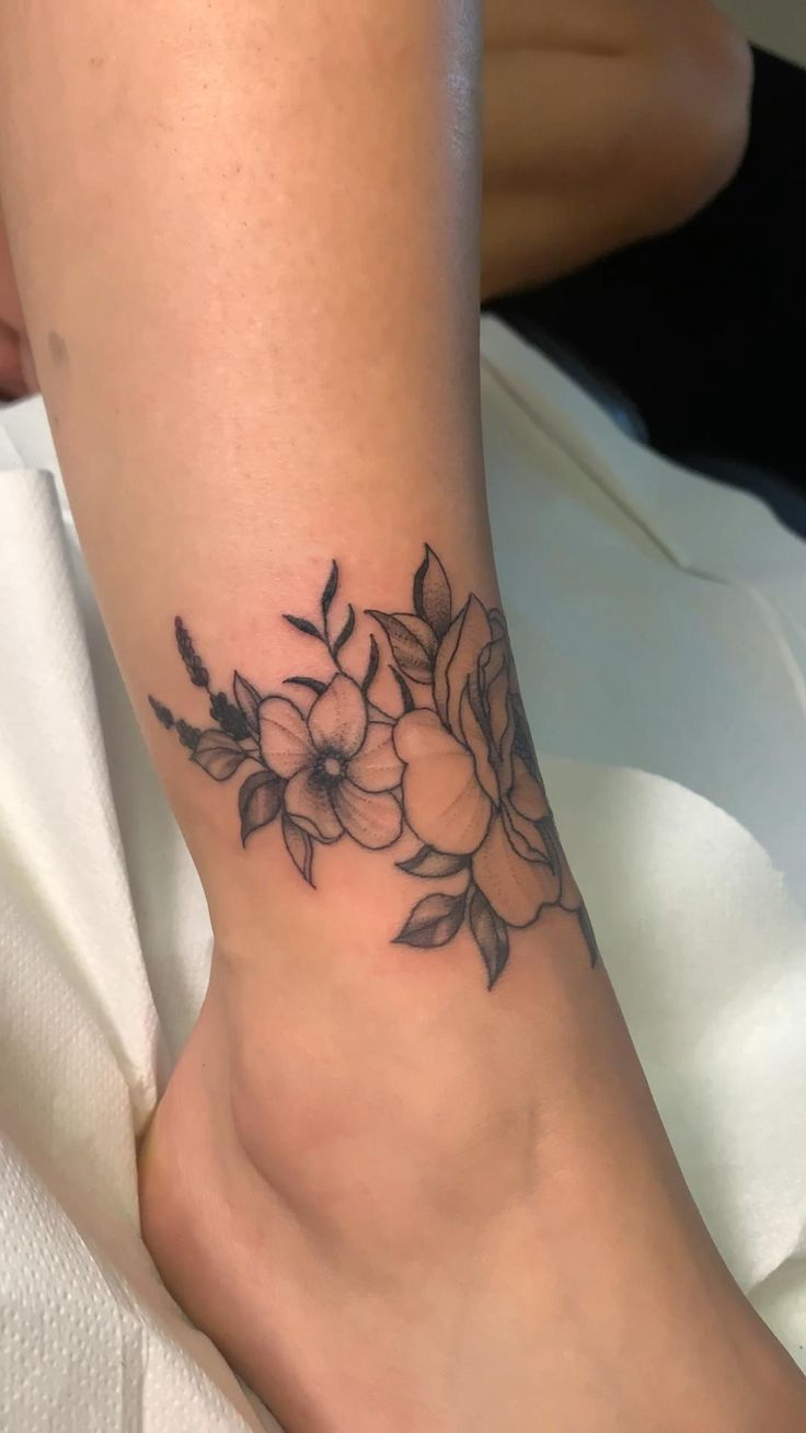 a woman's foot with a flower tattoo on it