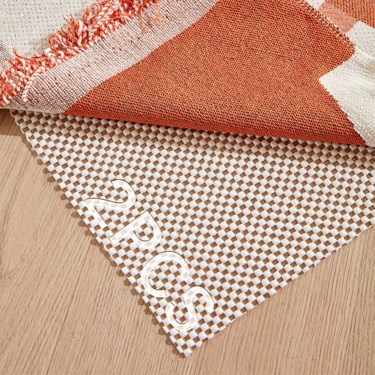 three pieces of fabric laying on top of each other, one orange and the other white