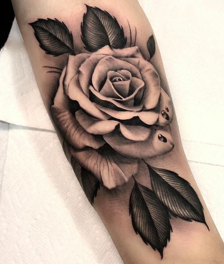 a black and white rose tattoo on the arm