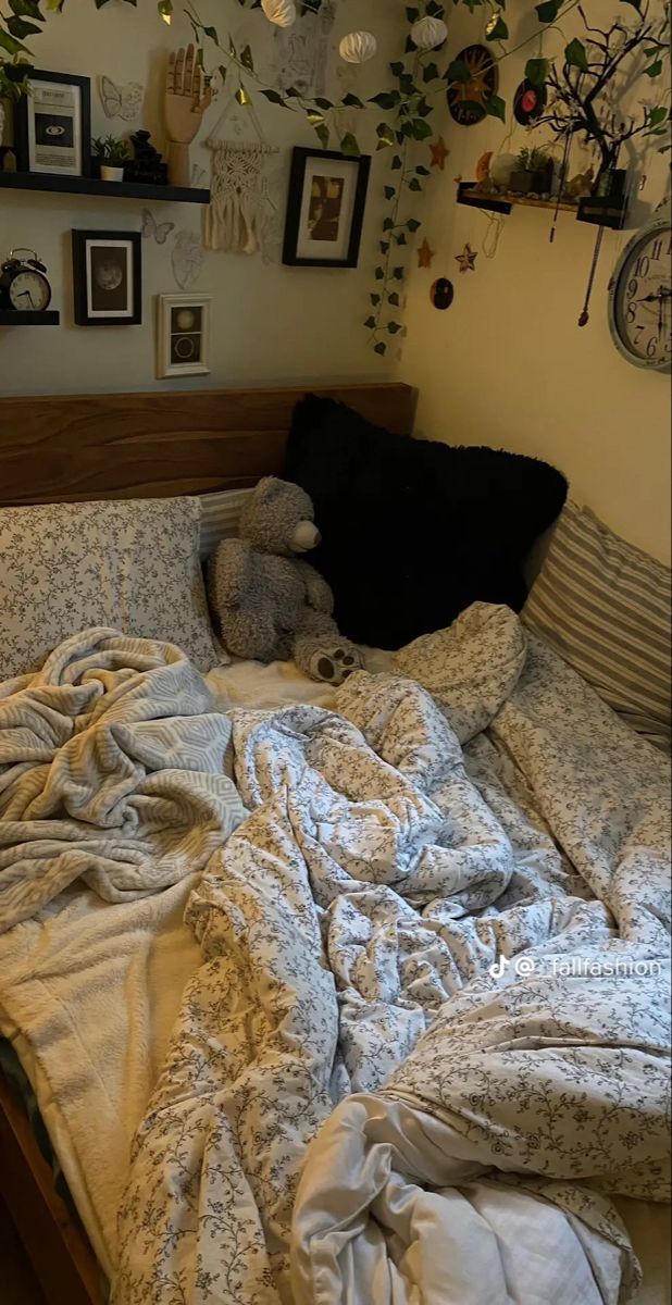 an unmade bed with lots of pillows and blankets