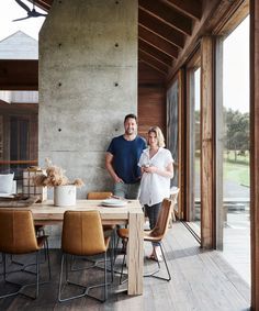 a man and woman standing next to each other in front of a dining room table