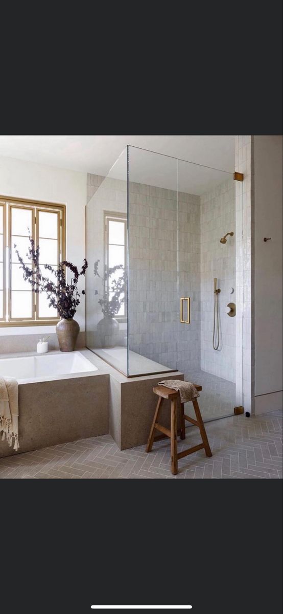 a bathroom with a tub, shower and stool next to the bathtub is shown