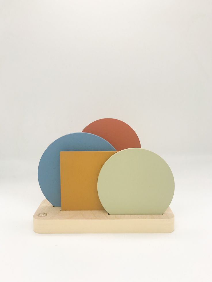 three different colored plates on a wooden stand