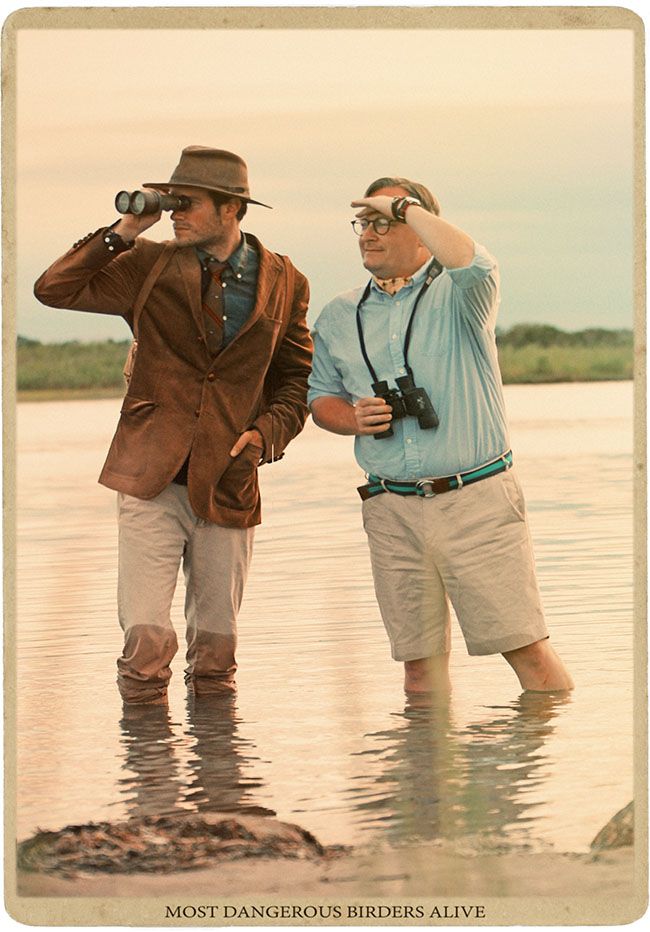 two men are standing in the water with binoculars