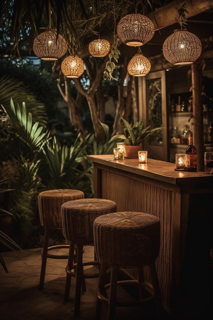 three wicker stools sitting at a bar with lights hanging from the ceiling