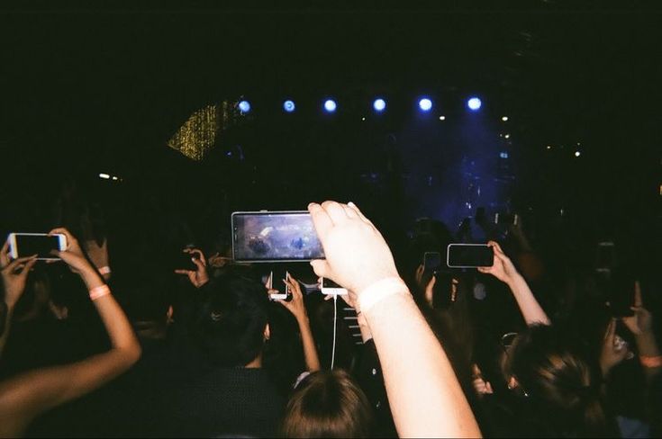 a crowd of people holding up their cell phones to take pictures at a music concert