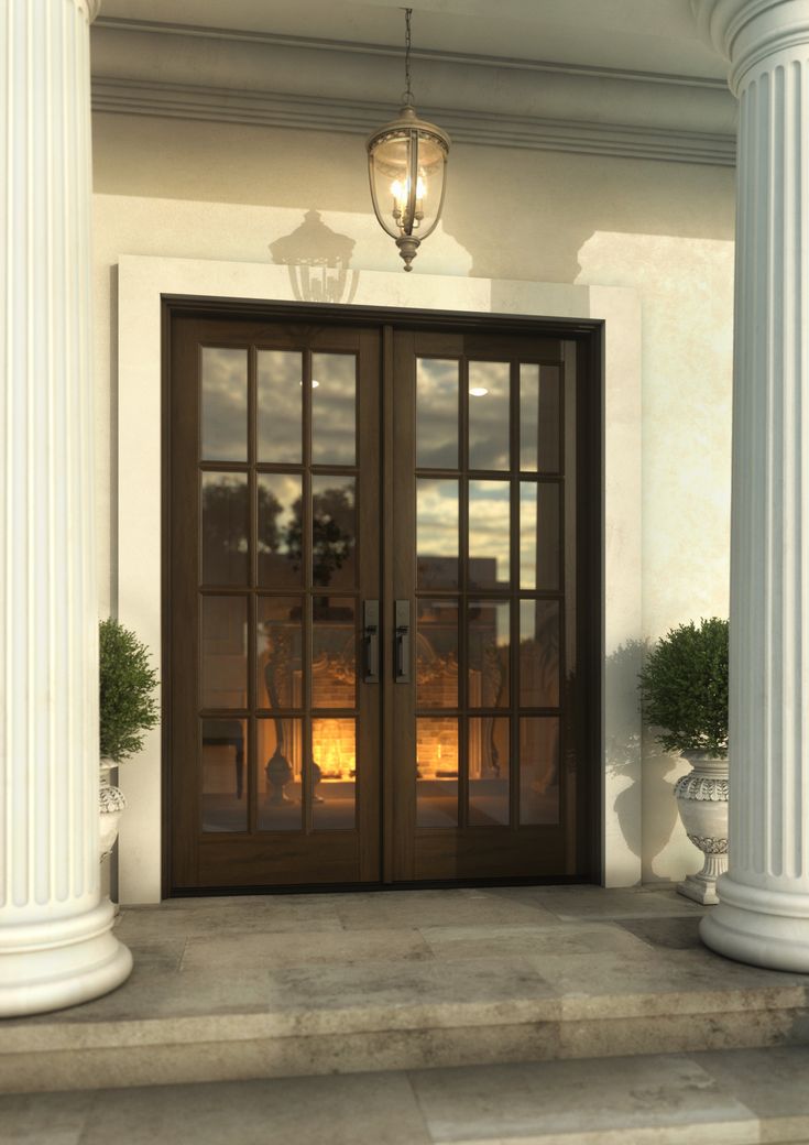 the front door to a house with columns and lights on it's side walk