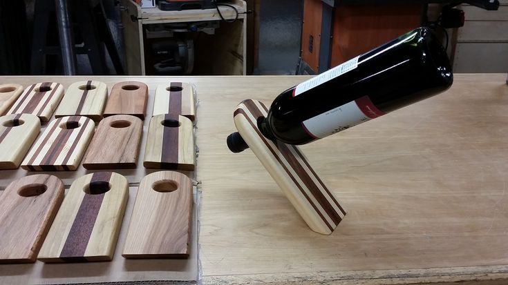 a bottle of wine sitting on top of a wooden table next to some pieces of wood