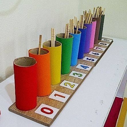 a row of colorful cups sitting on top of a wooden table next to each other