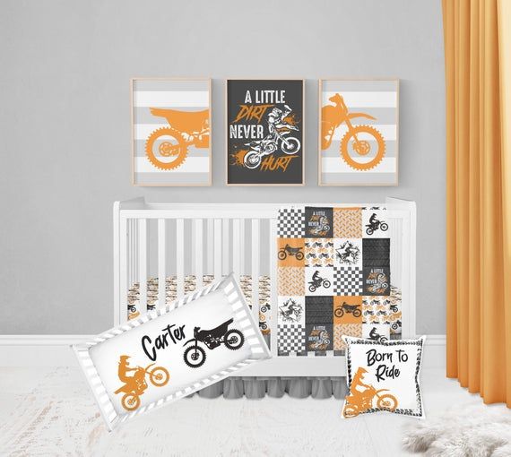 a baby crib bedding set with an orange and black motorcycle theme on it