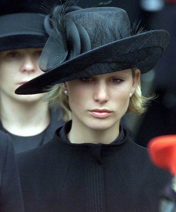 a woman wearing a black hat with feathers on it