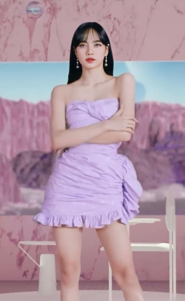 a woman in a short purple dress standing next to a table with a balloon on it