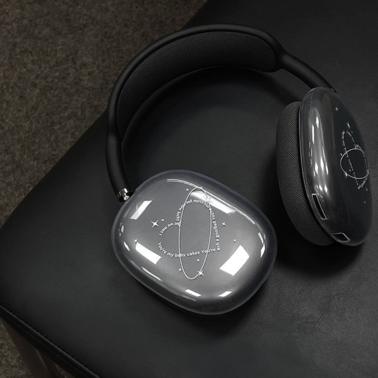 a pair of headphones sitting on top of a black table next to a computer mouse