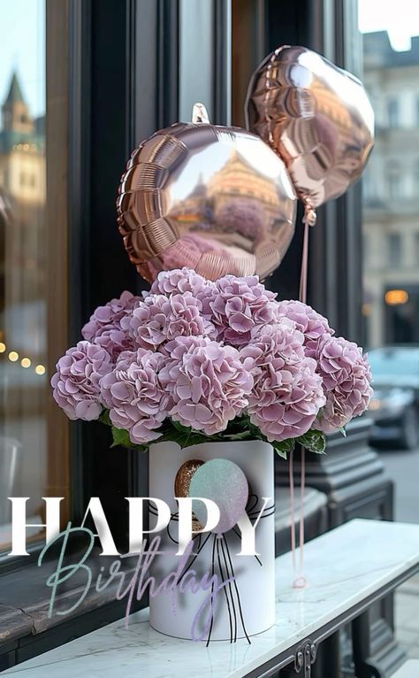 a vase filled with pink flowers sitting on top of a table next to a window