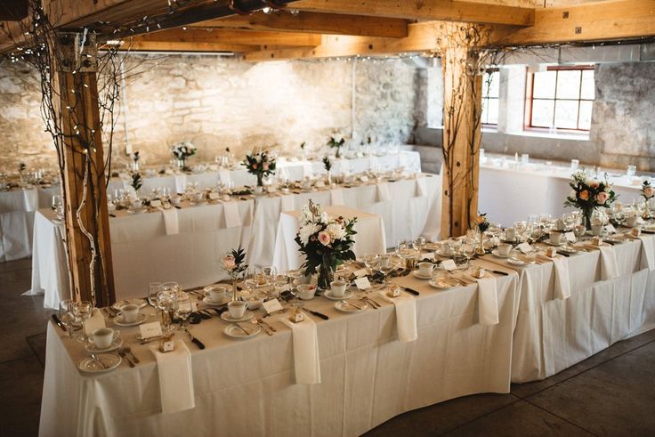 the tables are set with white linens and place settings