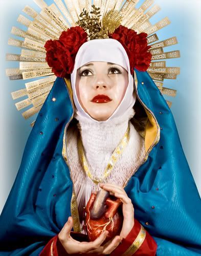 a woman dressed in blue and gold holding a heart