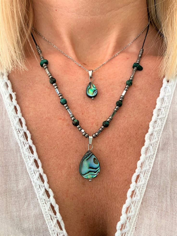 These fine handmade necklaces are made from the finest quality abalone shells, collected from off the coasts of the tropical islands around New Zealand. Amazing irization & rainbow colors inside one side of the shell1 Abalone is a very rare shell that on its inner surface produces thousands of layers of an organic substance called 'nacre' (pearl root) with a unique & intense rainbow iridescence! The Maori tribe of Australia calls it the 'Paua shell' & cherish it as a symbol of good luck & prosperity. They strongly believe that the shell's calmness & tranquility protect the person from any unpleasantness!  In 2 styles: a. Amazingly iridiscent Abalone shell teradrop 8x12mm with silver dainty 1,2mm, stainless steel chain!  +7cm chain extension to adjust perfectly!  b. Amazingly iridiscent Aba Mother Of Pearl Jewelry With Polished Beads For Gifts, Unique Shell Beaded Necklaces For Gifts, Natural Stones Shell Necklace As A Gift, Unique Shell Beaded Necklace For Gift, Mother Of Pearl Shell Beaded Necklaces For Gifts, Unique Shell Shaped Beaded Necklace For Gift, Handmade Bohemian Beaded Necklaces In Iridescent Color, Unique Shell Necklace With Round Beads For Gift, Unique Round Beads Shell Necklace As Gift