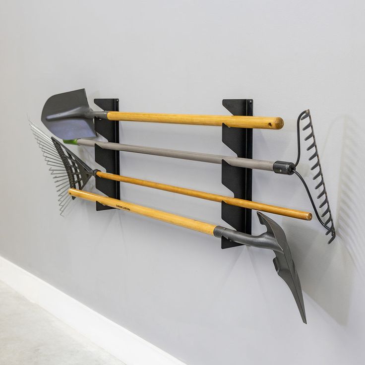 an assortment of gardening utensils hanging on a wall