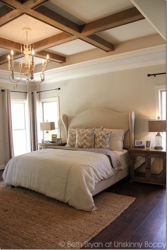 a bedroom with a large bed, chandelier and two lamps on the ceiling