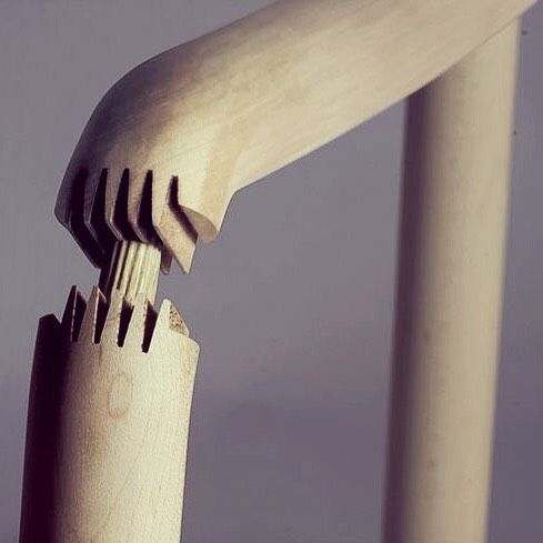 a wooden fork sticking out of the side of a white pole