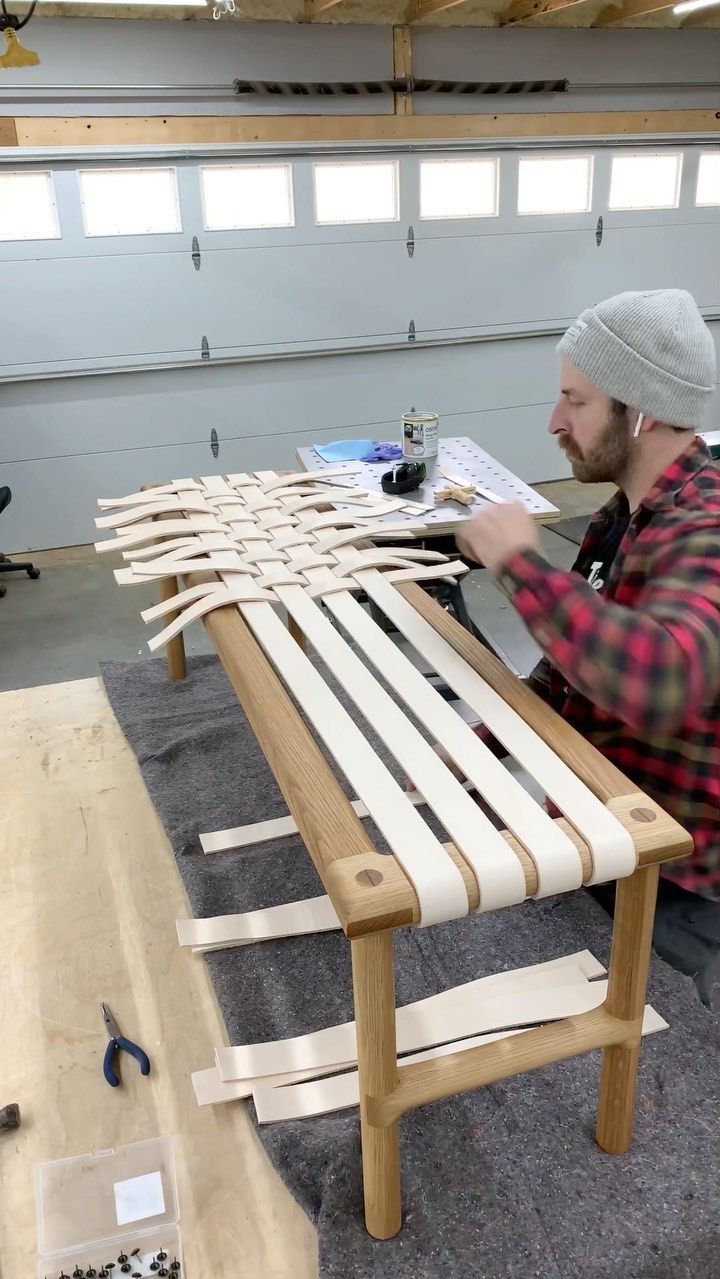 a man working on a wooden bench in a garage