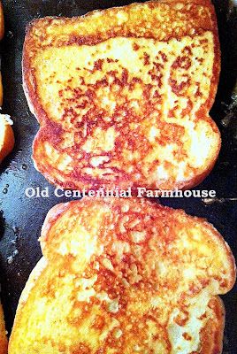 three pieces of french toast cooking in a skillet