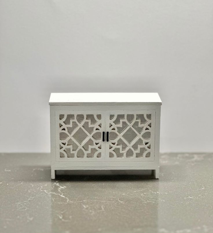 a small white cabinet sitting on top of a table