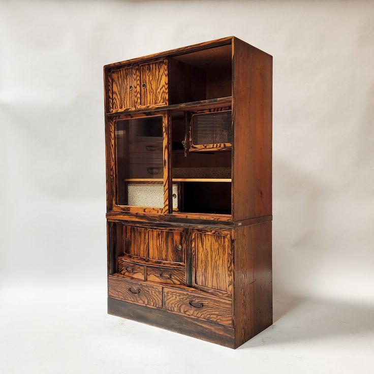 an old wooden bookcase with drawers and cupboards on the front, against a white background