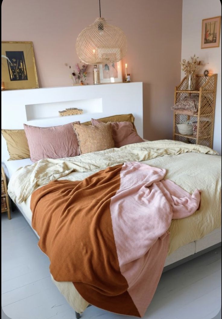 a bed with blankets and pillows on it in a room that has white flooring