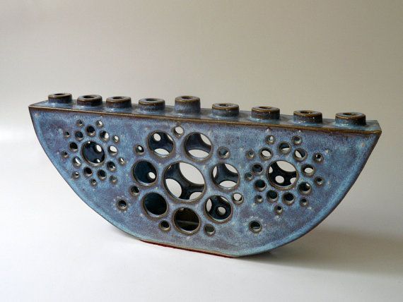 a blue vase with holes in it sitting on a table