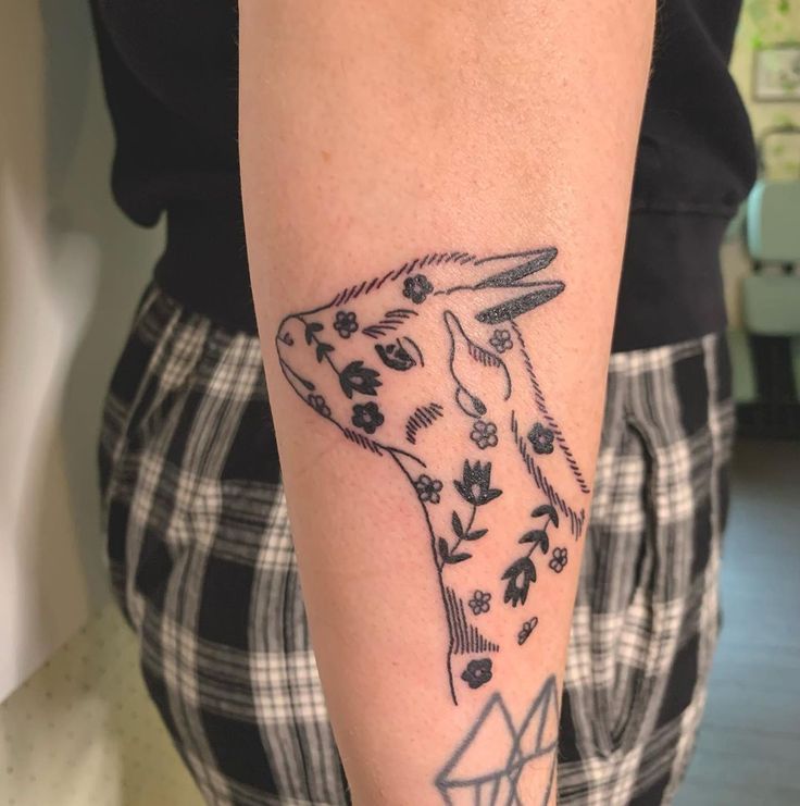 a person with a goat tattoo on their arm