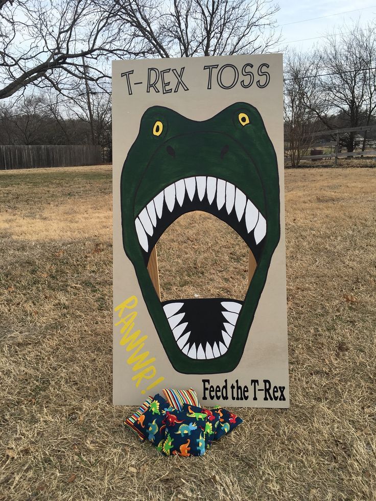 a sign that says feed the t - rex with an image of a dinosaur's mouth