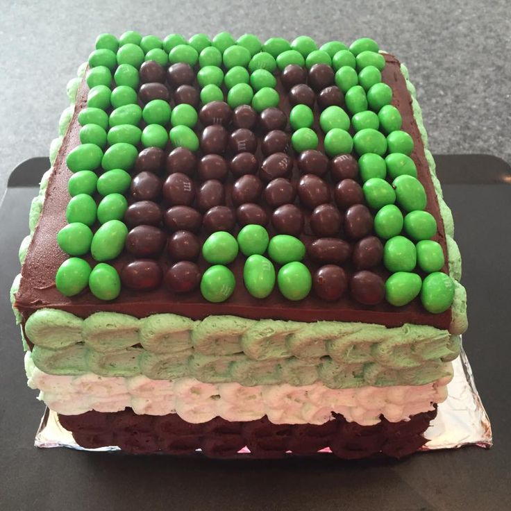 a cake with green and brown icing on it sitting on top of a table