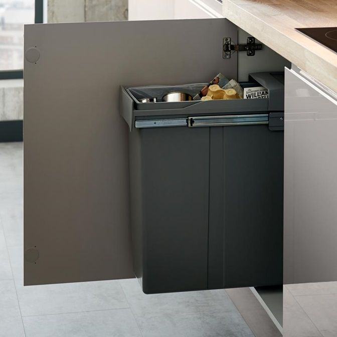 an open trash can in the corner of a kitchen