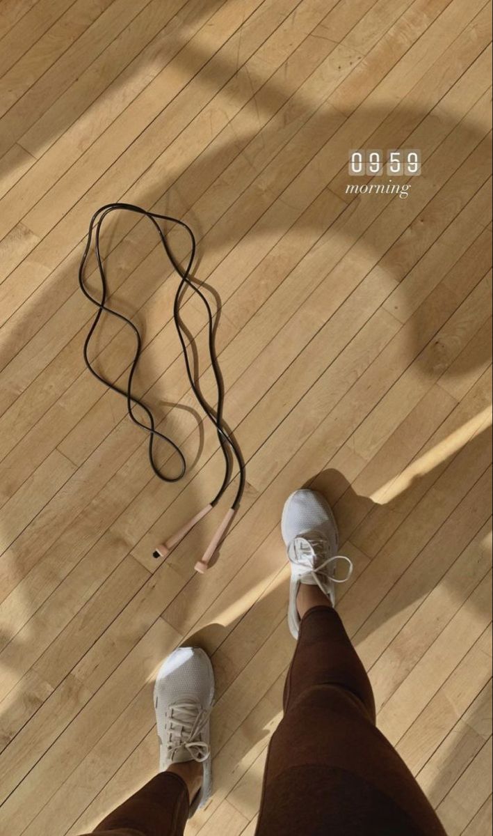 a person standing on top of a wooden floor next to a string and shoelace