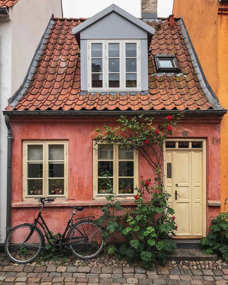 a bicycle is parked in front of a house with flowers painted on the side of it