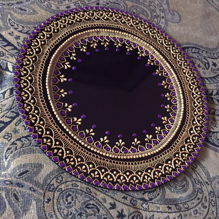 a purple and gold plate sitting on top of a table