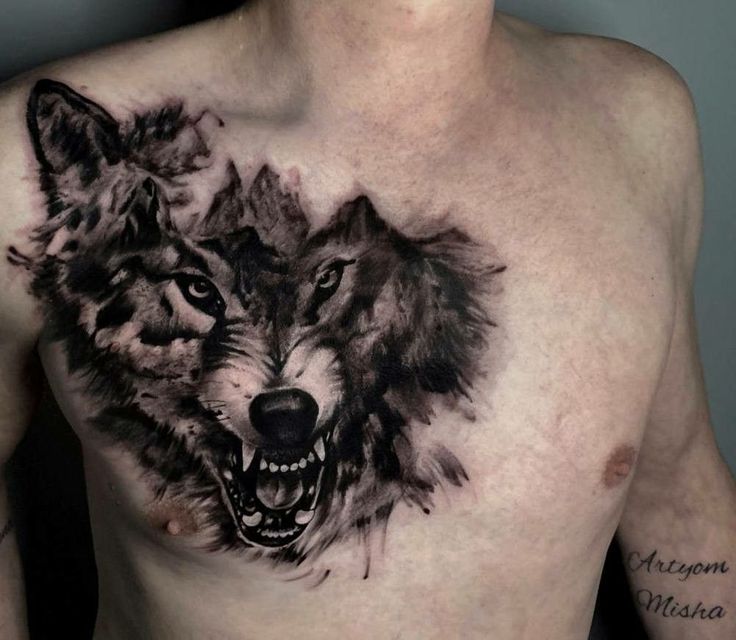 a man's chest with two wolfs on it and his face painted in black ink