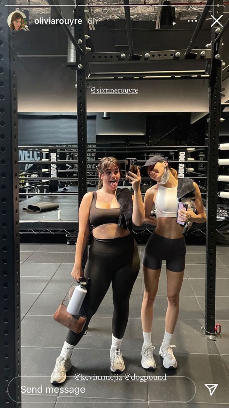 two women in black and white outfits posing for a selfie with their cell phones