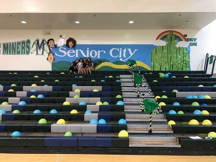 an empty bleachers filled with blue and green balls in front of a sign that reads senior city