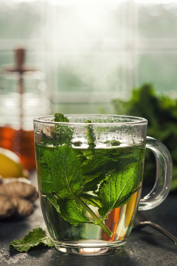 a glass cup filled with green tea and mint