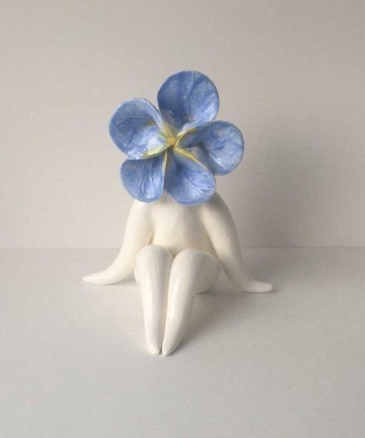 a blue flower sitting on top of a white table