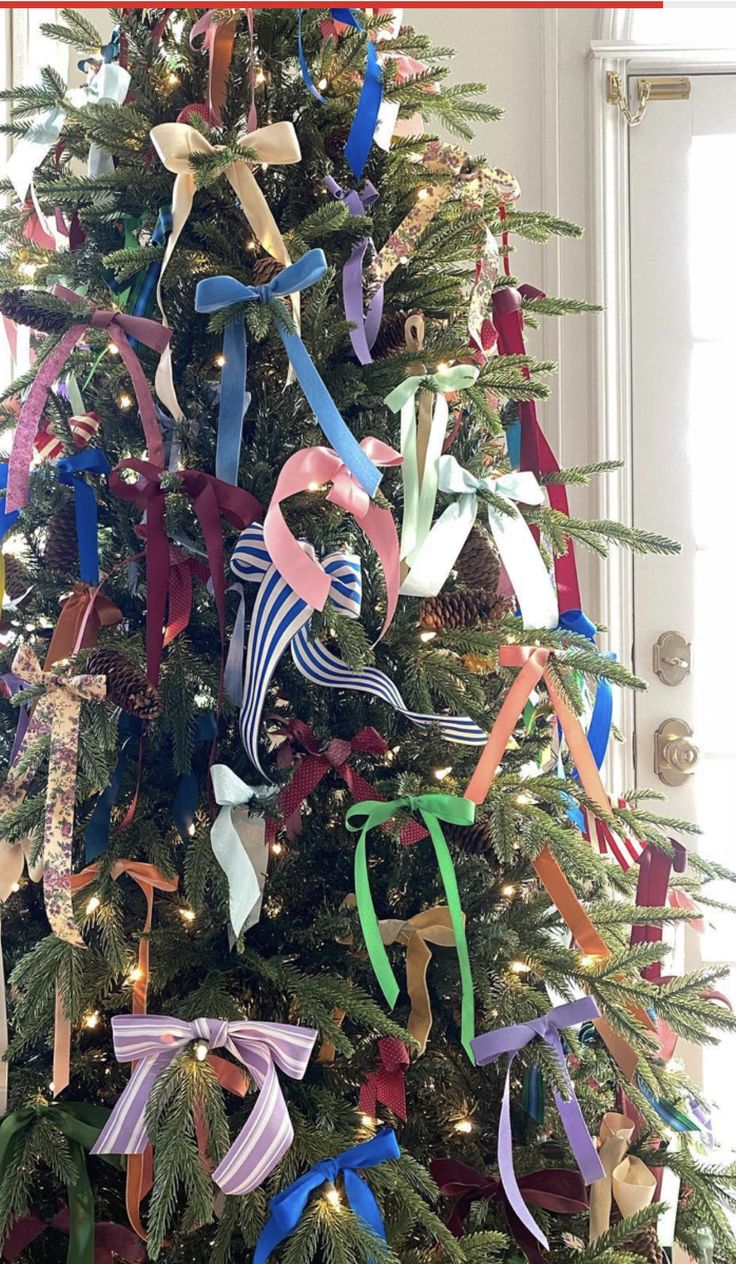 a decorated christmas tree with ribbons on it