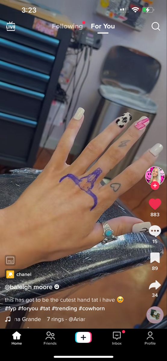 someones hand with tattoos on it and some other things in front of the camera