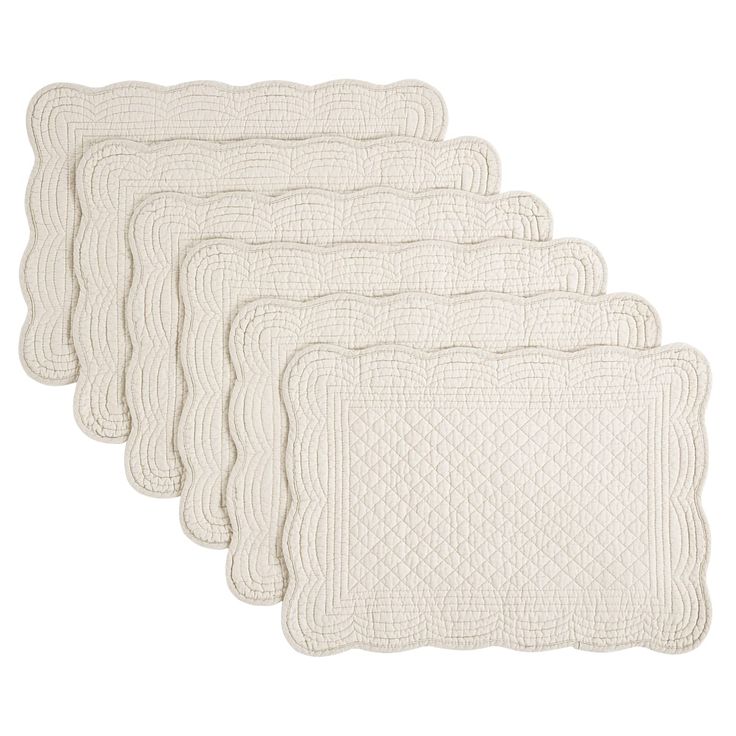 four white quilted placemats on a white background