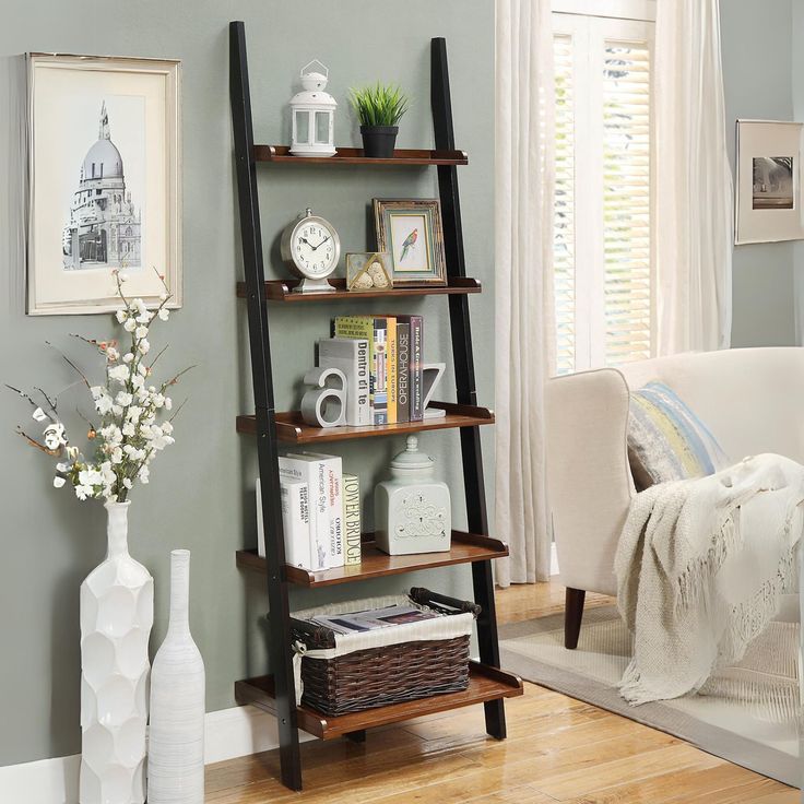 a living room filled with furniture and a tall shelf next to a window covered in curtains