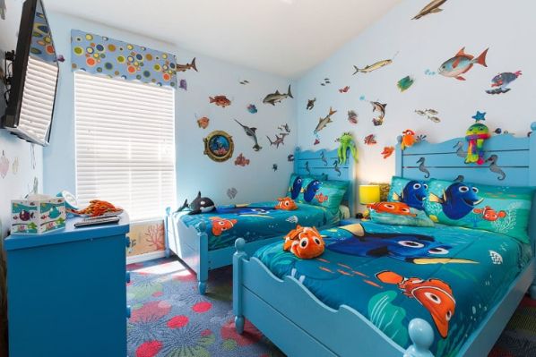 two children's beds in a brightly colored room with fish on the wall and ceiling