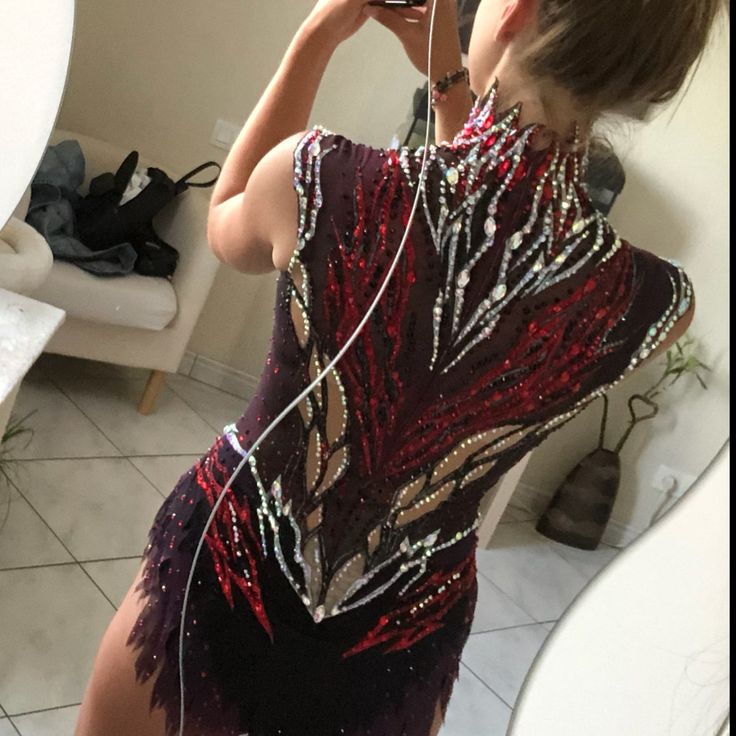 a woman taking a selfie in front of a mirror wearing a dress with sequins