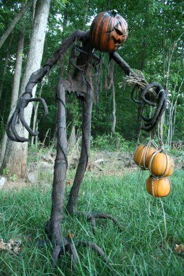 an image of a halloween decoration made out of vines and pumpkins in the grass