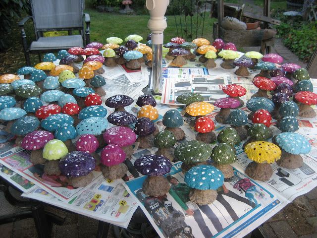 a table topped with lots of different colored mushrooms on top of paper and plastic cups